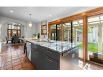 Kitchen island with granite countertops, stainless steel appliances, and access to backyard patio at 4525 King St, Denver, CO 80211