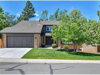 Charming home with a well-manicured lawn and a two-car garage provides great curb appeal at 11209 Quivas Loop, Denver, CO 80234
