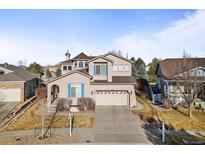 Charming two-story home featuring stucco siding, attached two-car garage and well-manicured front lawn at 1446 S Grand Baker Cir, Aurora, CO 80018