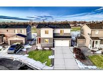 Charming two-story home with gray siding, manicured lawn, and a two-car attached garage at 1867 Homestead Dr, Fort Lupton, CO 80621