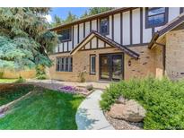 Charming Tudor-style home with brick facade, well-manicured lawn, and inviting walkway at 14198 W 3Rd Pl, Golden, CO 80401