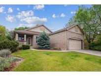 Charming brick home with a well-manicured lawn and mature landscaping at 21063 E Greenwood Pl, Aurora, CO 80013