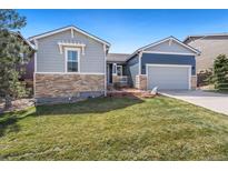 Charming home with a well-manicured lawn and a blend of stone and siding accents for added curb appeal at 13844 W Marlowe Cir, Morrison, CO 80465