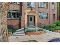 Charming brick building entrance featuring decorative stonework, landscaping, and a secure entry at 1060 N Washington St # 1A, Denver, CO 80203