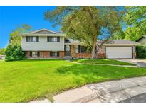 Charming two-story home with a well-manicured lawn and mature landscaping, creating inviting curb appeal at 3266 S Wabash Ct, Denver, CO 80231