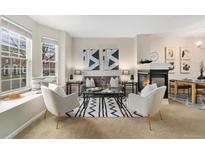 Cozy living room featuring a fireplace, stylish seating, and a bright bay window with a cushioned seat at 3974 W 118Th Pl, Westminster, CO 80031
