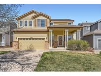 Charming two-story home features a welcoming covered porch, a two-car garage, and a well-manicured lawn at 6853 W Rockland Pl, Littleton, CO 80128