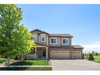 Charming two-story home with a well-manicured lawn, a three-car garage, and stone accents at 15352 E 117Th Ave, Commerce City, CO 80022