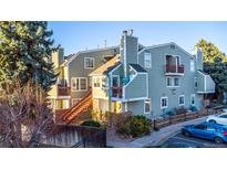 Inviting exterior of the townhome with red accents on the balcony railings and stair rails at 919 S Dawson Way # 7, Aurora, CO 80012