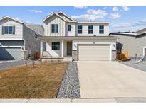 Charming two-story home featuring a two-car garage, stone accents, and a well-maintained front yard at 4511 Boone Cir, Brighton, CO 80601