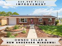 Charming brick home featuring owned solar panels, new Andersen windows, and beautifully landscaped front yard at 5593 E Center Ave, Denver, CO 80246