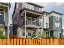 Charming two-story townhome with a balcony, fenced yard, and colorful siding at 14998 Cast Pebble Cir, Parker, CO 80134