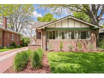 Charming brick home featuring a well-manicured lawn, brick accents, and lush landscaping at 1767 S Sherman St, Denver, CO 80210
