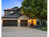 Charming home featuring a three-car garage, gray paint, brick accents, and a well manicured lawn at 6175 Puma Sands, Lone Tree, CO 80124