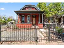 Charming red brick home with a covered front porch, stately columns, and a wrought-iron fence at 1103 Lipan St, Denver, CO 80204