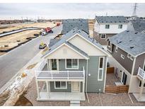 New construction two-story home with charming balcony and gray vinyl siding at 13615 E 103Rd Ave, Commerce City, CO 80022
