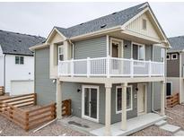 Charming two-story home with a second story balcony and neutral gray siding at 13615 E 103Rd Ave, Commerce City, CO 80022