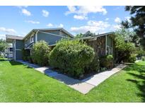 Charming townhome with lush landscaping, grassy lawn, and stone facade at 2246 N Coronado Pkwy # A, Denver, CO 80229