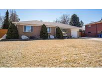 Charming brick home featuring a large front yard with mature trees and a two-car garage at 8910 W 4Th Ave, Lakewood, CO 80226