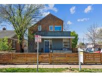 Stylish home featuring a unique facade, wood fence, and lush greenery, offering charm and curb appeal at 190 W Archer Pl, Denver, CO 80223
