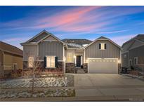 Beautiful two-story home featuring a two-car garage, well-maintained lawn, and inviting entrance at dusk at 9028 S Catawba St, Aurora, CO 80016