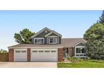 Charming two-story home with a well-manicured lawn, brick accents, and a two car garage at 9229 Sugarstone Cir, Highlands Ranch, CO 80130
