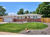 Charming single-story home with a well-manicured lawn, brick accents, and mature trees at 1687 S Field Ct, Lakewood, CO 80232