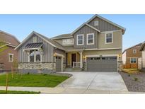 Charming two-story home featuring a well-manicured lawn, attached two-car garage, and stone accents at 4586 Windmill Dr, Brighton, CO 80601