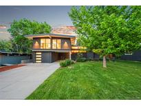 Contemporary two-story home featuring large windows, a well-manicured lawn, and an attached garage at 1440 S Dahlia St, Denver, CO 80222