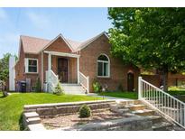 Charming brick home with a well-maintained front yard and inviting entryway at 3036 Birch St, Denver, CO 80207