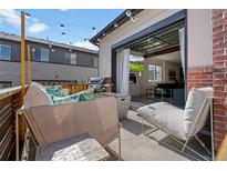 Relaxing outdoor patio with stylish lounge seating, fire pit, and sliding glass doors leading to the home's interior at 12843 W Nevada Pl, Lakewood, CO 80228