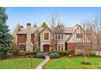 Charming stone and brick home with a well-manicured lawn and inviting walkway at 17 Polo Club Dr, Denver, CO 80209