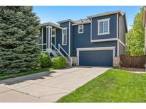 Charming two-story home with blue siding, white trim, well-manicured lawn, and an attached two-car garage at 104 Willowick Cir, Highlands Ranch, CO 80129