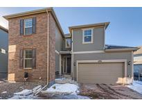 Two-story home with brick and siding exterior, attached garage, and landscaping at 9308 Inca Dove Cir, Littleton, CO 80125