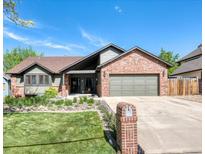 Charming exterior showcasing a well-manicured front yard and a brick and siding facade under a blue sky at 13830 Silverton Dr, Broomfield, CO 80020