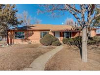 Charming single-story brick home with a well-maintained front yard and mature trees at 760 Scranton Ct, Aurora, CO 80011