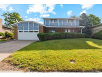 Two-story home with brick and blue siding, featuring a two-car garage and a well-manicured front lawn at 4522 S Robb St, Littleton, CO 80127
