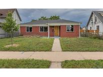 Charming single-story brick home with a well-manicured lawn and inviting walkway at 4453 Fillmore St, Denver, CO 80216