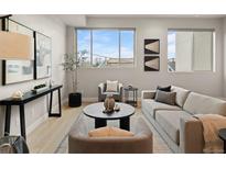 Bright living room with modern furnishings, decor, and a large window providing natural light at 4733 E Iliff Ave, Denver, CO 80222