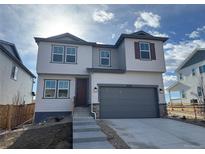 Charming two-story home with a two-car garage and light-gray siding at 16528 W 92Nd Pl, Arvada, CO 80007