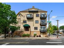 Multi-level condo building boasting several balconies, a street view and manicured landscaping at 3299 Lowell Blvd # 204, Denver, CO 80211