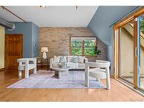 Modern living room features a brick accent wall, light wood floors, and stylish furniture for a cozy and inviting atmosphere at 3299 Lowell Blvd # 204, Denver, CO 80211