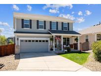 Charming two-story home featuring a covered front porch, landscaped yard, and an attached two-car garage at 11866 High Desert Rd, Parker, CO 80134