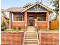 Charming brick home with a covered front porch and manicured landscaping at 3085 W 36Th Ave, Denver, CO 80211