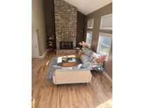 Bright living room with a stone fireplace, hardwood floors and lots of natural light at 5429 S Waco St, Centennial, CO 80015