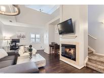 Bright and modern living room with high ceilings, fireplace, and hardwood floors at 5420 Allison St # 202, Arvada, CO 80002