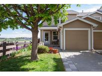 Inviting home with a charming front yard, lush lawn, lovely flowers, and an attached single-car garage at 2296 E 109Th Dr, Northglenn, CO 80233