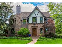 Charming Tudor-style home with a stone facade, lush landscaping, and a welcoming front entrance at 1795 N Monaco St Pkwy, Denver, CO 80224