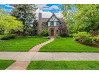 Charming stone Tudor home with a manicured front yard and a stone walkway leading to the front door at 1795 N Monaco St Pkwy, Denver, CO 80224