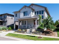 Charming two-story home with white siding, inviting front porch, and well-maintained landscaping at 8461 E 54Th Dr, Denver, CO 80238